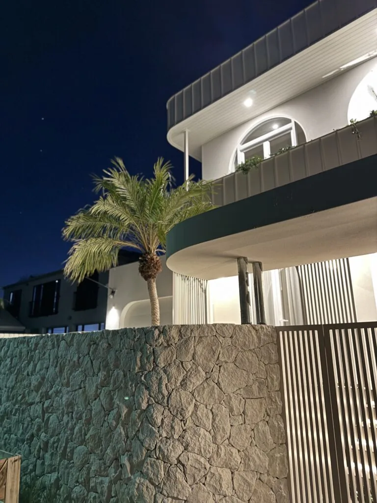 Natural stone wall at a contemporary Gold Coast home, lit at night