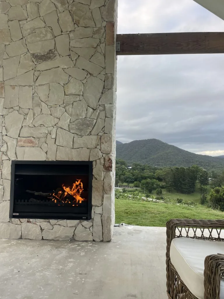 Natural stone clad outdoor fireplace overlooking the Gold Coast hinterland